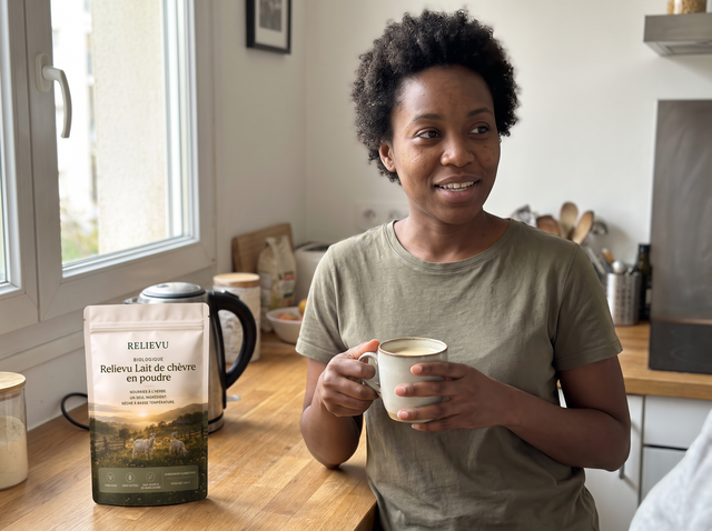 Cliente tenant une tasse de café au lait, le sachet posé sur le plan de travail